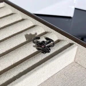 Anillo gótico de espinas con gema roja y rosa negra en bandeja de joyería de lujo