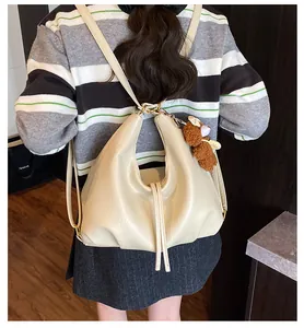 Back view of a woman wearing a stylish cream large capacity commuter travel backpack