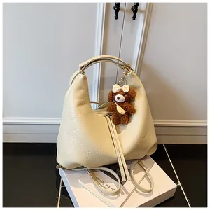 Cream-colored textured faux leather multi-functional backpack with cute teddy bear charm