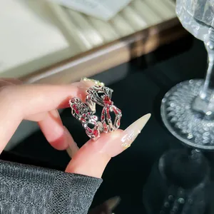 Detailaufnahme eines dunklen roten Spinnennetz-Rings im Punk-Stil für Damen Schmuck.