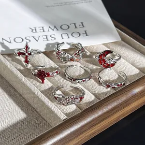 Gothic-Punk-Ringe-Set mit rotem Emaille-Kreuz und Mondmotiven in einer Schmuckschale