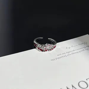 Makroansicht von Punk-Gothic-Ring aus Silber mit Spinnennetz und roten Edelsteinen