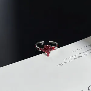 Detailansicht eines Punk-Silberrings mit einem auffälligen roten Tropfendesign aus Harz.