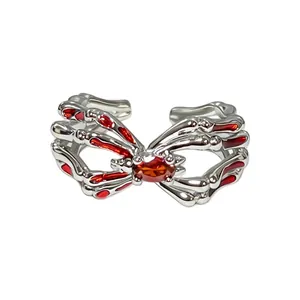 Makro-Detail eines gotischen Punk-Silber-Spinnenringes mit lebhaften roten Steinen