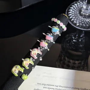 Detailopname van kleurrijke emaille appelringen op een zwarte fluwelen displaystand