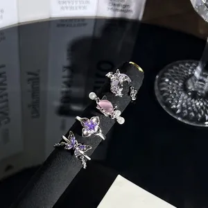 Detailansicht von vier silbernen Ringen mit lila Schmetterling und rosa Katzen Motiven