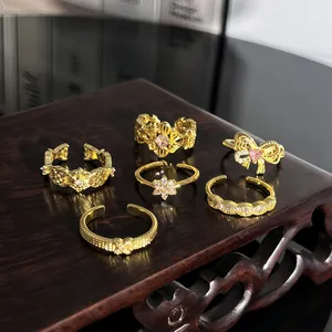 Sammlung französischer Vintage-Goldringe mit rosa Steinen auf einem dunklen Holzständer