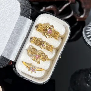 Detailansicht von vier vergoldeten Vintage-Ringen mit rosa Kristallen in einer Box