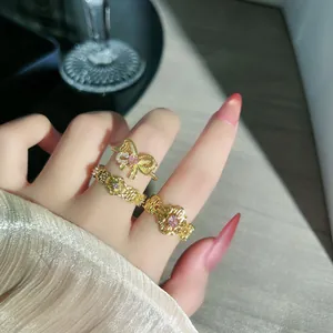 Nahaufnahme von französischen Retro-Ringen mit Goldbeschichtung, Spitze und rosa Steinen