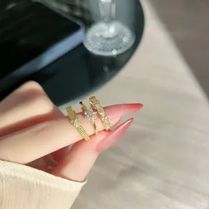 Detailansicht von drei vintage goldfarbenen Spitzenringen mit rosa Steinen am Finger