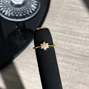 Detailansicht eines eleganten goldenen Blumenrings mit rosa Kristallen auf Ständer