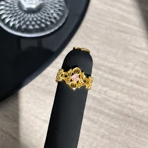 Nahaufnahme eines goldenen Vintage-Spitzenrings im französischen Stil mit rosa Stein