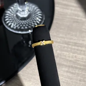 Makrodetail eines französisch vergoldeten Spitzenrings mit funkelndem Schleifendesign