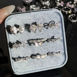 Detailaufnahme von neun silbernen Schleifenringen mit Strass in einer blauen Samtbox