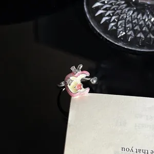 Detailopname van een onregelmatige roze emaille appelring met glinsterende zirkoon