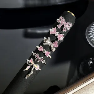 Detailansicht von sechs funkelnden rosa Schleifen-Ringen auf schwarzem Ständer