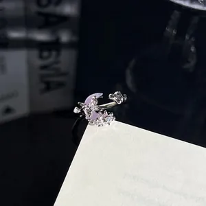 Nahaufnahme eines silbernen Rings mit lila Mond und Schmetterling aus Zirkonia-Steinen
