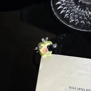 Close-up detail van een creatieve groene emaille appelring met florale kristalaccenten
