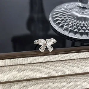 Detailaufnahme eines funkelnden silbernen Rings in Schleifenform mit Vollbesatz.