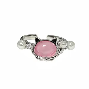 Detailansicht eines silberfarbenen Katzenrings mit rosa Stein, Perlen und Glitzersteinen