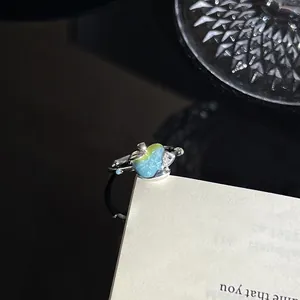 Een gedetailleerd zijaanzicht van de onregelmatige appel emaille ring met verloop