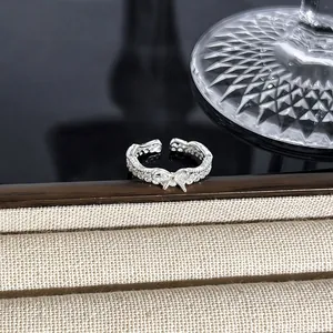 Detailaufnahme eines funkelnden silbernen Schleifenrings mit Vollbesatz auf Textur.