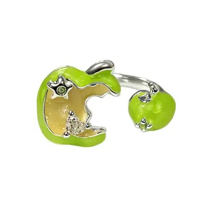 Detailweergave van een verstelbare ring met groene emaille appel en kristallen