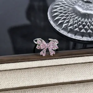Makroansicht eines eleganten silbernen Schleifenrings mit rosa Kristallen auf Schmuck.