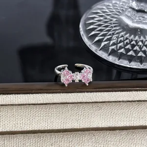 Detailansicht eines rosa schleifenförmigen Rings mit Zirkonsteinen und verstellbarem Band