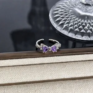 Makroansicht eines Silberrings mit violetten Herzsteinen in Schleifenform Detail