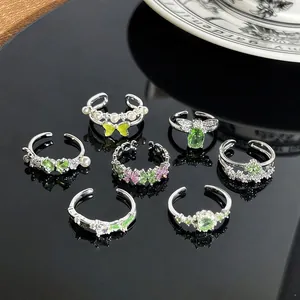Detailansicht einer Kollektion zarter grüner Kristall-Schmetterlingsringe in Silber
