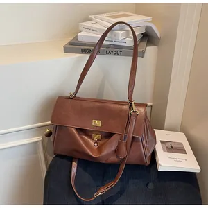 Professional studio shot of a large brown retro shoulder tote bag with gold hardware