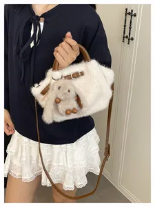 White faux fur tote bag with brown straps and cute rabbit charm shown on model.