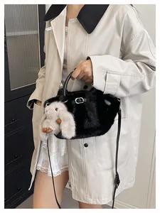 Close-up view of a stylish black plush crossbody bag featuring a cute bunny charm