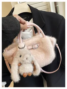 Close-up detail of soft pink faux fur plush handbag featuring a cute bunny charm