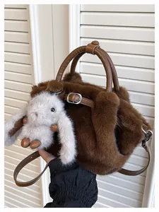 Detailed view of a brown plush faux fur tote bag featuring a cute white bunny charm accessory