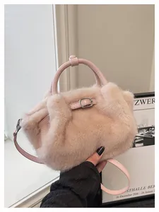 Detailed macro view of the soft pink faux fur texture on a luxury women's winter handbag