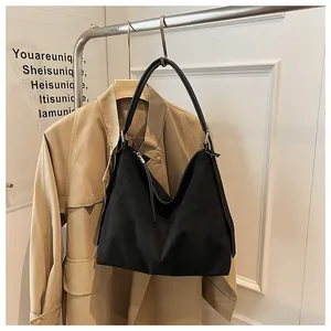 Bolso tote negro minimalista de gran capacidad colgado de un estante en un estudio