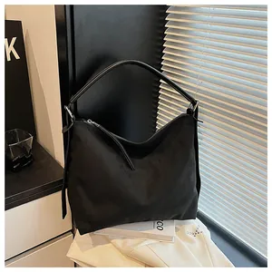 Vista lateral de un bolso hobo vintage negro minimalista en un fondo de interior