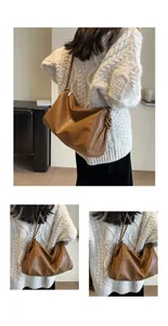 Dettaglio borsa hobo marrone vintage indossata con maglione bianco a trecce