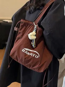 Brown large capacity tote bag with white BANATU text logo on model shoulder