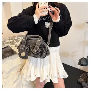 Detailed outfit view of washed denim bowling crossbody bag with heart mirror charm