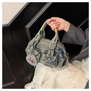 Close-up of a vintage denim bowling bag with buckle details and heart mirror charm