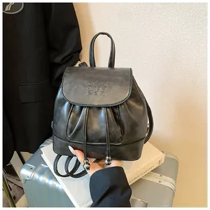 Detailansicht des schwarzen Mini-Rucksacks aus Kunstleder mit Kordelzug und Klappe.