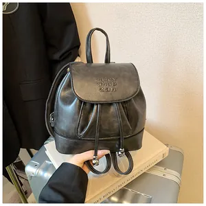 Nahaufnahme eines weichen schwarzen Lederrucksacks mit Kordelzug und Prägebuchstaben.