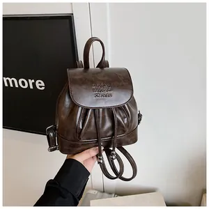 Detailansicht eines modischen kleinen Damenrucksacks aus braunem PU-Leder in der Hand