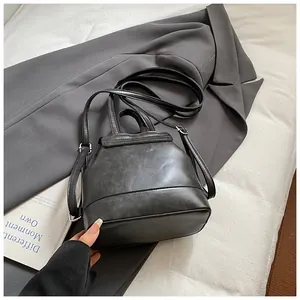 Detailansicht eines weichen schwarzen Damenrucksacks aus Kunstleder auf grauem Stoff