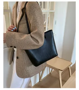 Lifestyle detail of a black minimalist large capacity leather tote bag for women