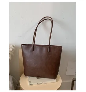 Elegant large brown textured leather tote bag on wooden stool for women commute