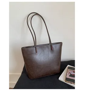 Minimalist dark brown leather tote bag with long shoulder straps for commuting use